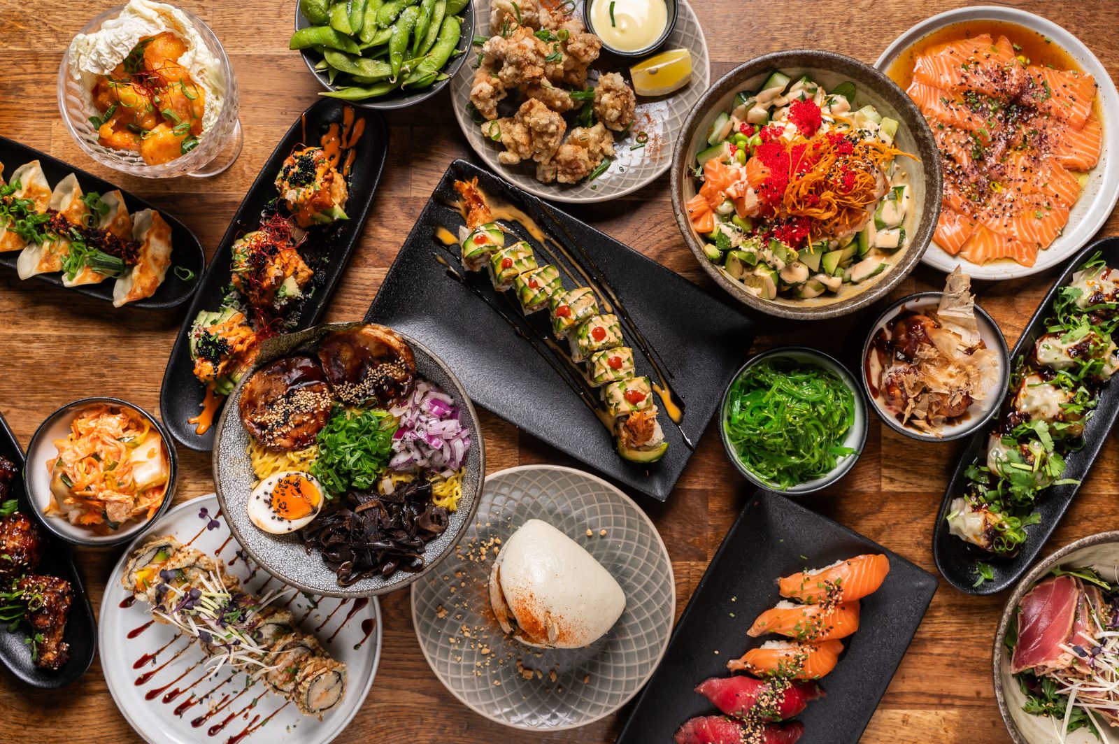 Viele Izakaya-Gerichte zum Teilen auf einem Holztisch im DAIKAN